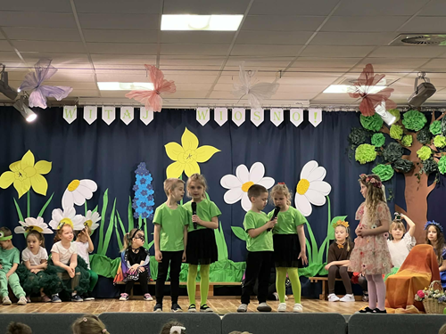 Zdjęcie przedstawia dzieci występujące na scenie