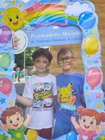 dwóch chłopców trzyma fotobudkę