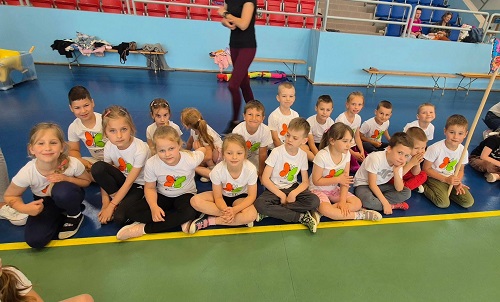 dzieci siedzą na hali