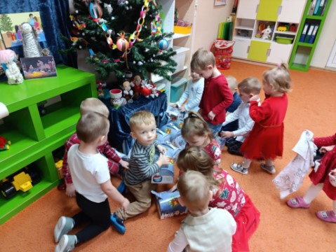 Na obrazku widać dzieci z paczkami.