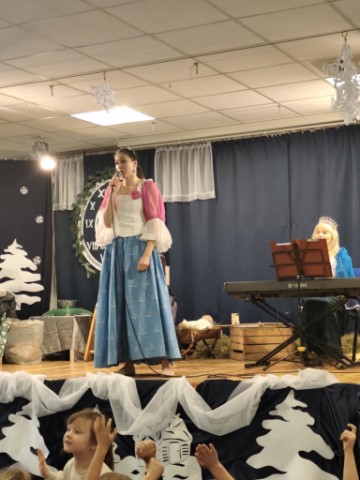 Na obrazku widac panią opowiadającą historię o Śpiącej królewnie.