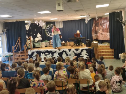 na obrazku widać uważnie słuichające dzieci.