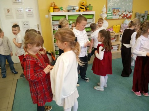 Na obrazku widać dzieci składające sobie życzenia.