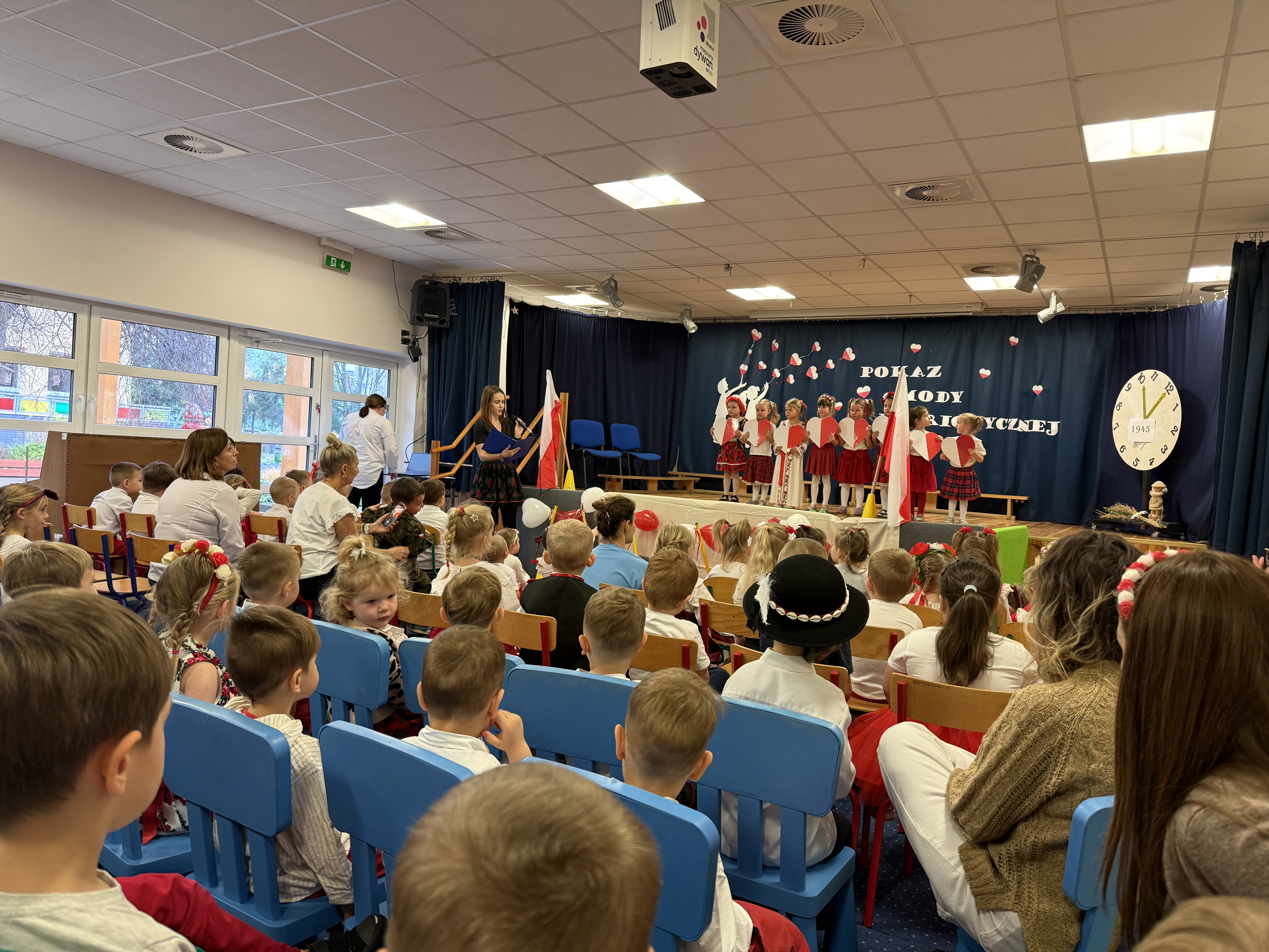 Zdjęcie przedstawia dzieci na scenie oraz widzów