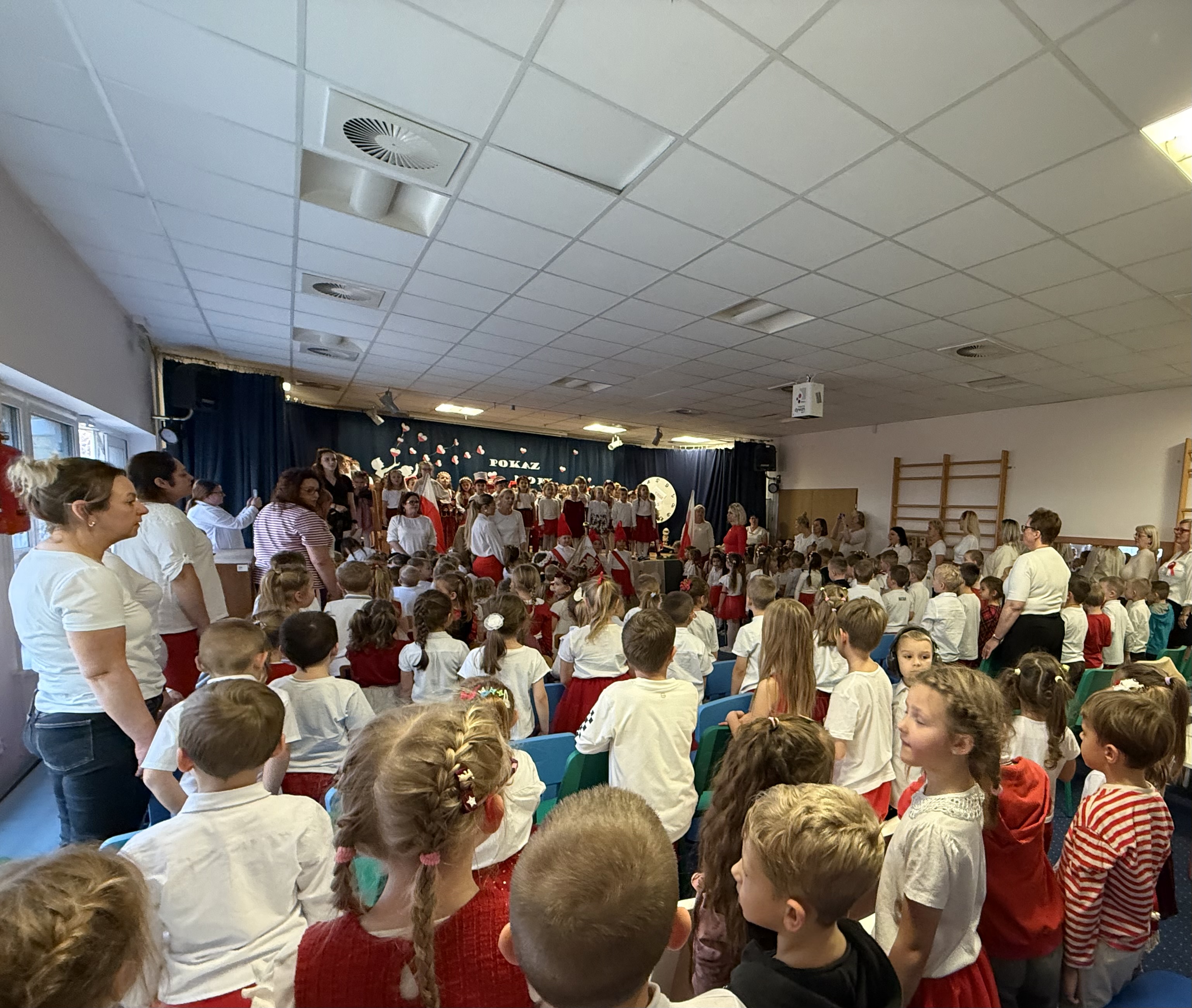 Zdjęcie przedstawia dzieci oraz kadrę przedszkola stojących na baczność