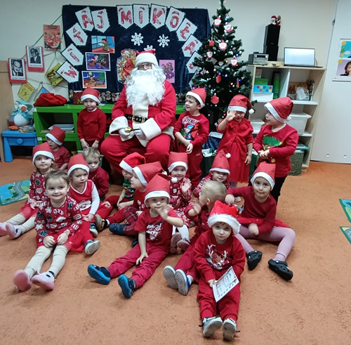 Na zdjęciu widzimy Mikołaja z dziećmi w sali przedszkolnej