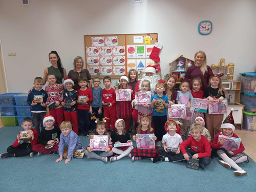 Zdjęcie przedstawia przedszkolaki na spotakniu z Mikołajem w swojej sali przedszkolnej
