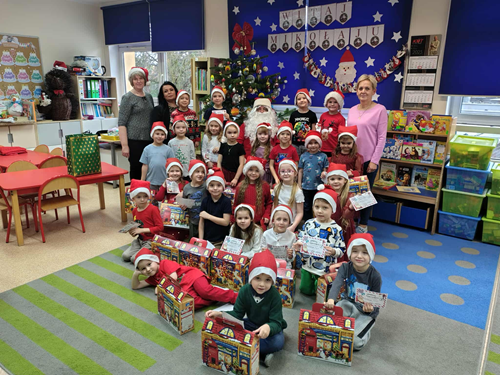 Zdjęcie przedstawia grupę dzieci wraz z Mikołajem i swoimi nauczycielkami w sali przedszkolnej
