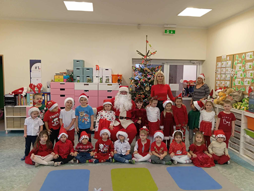 Zdjęcie przedstawia grupę dzieci na spotkaniu z Mikołajem