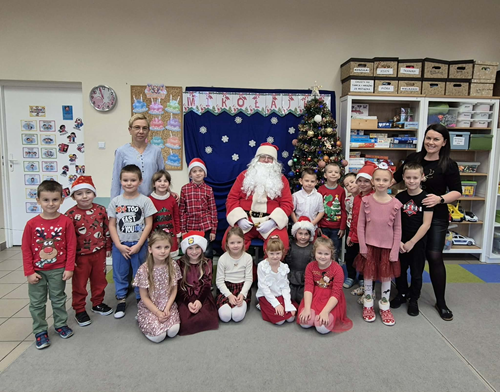 Zdjęcie przedstawia grupę dzieci ustawionych do zdjęcia podczas spotkania z Mikołajem