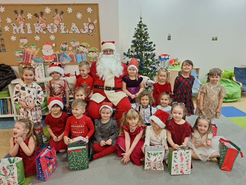 Zdjęcie przedstawia spotkanie Mikołaja z dziećmi w sali przedszkolnej