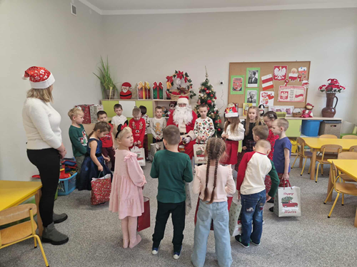 Zdjęcie przedstawia spotkanie Mikołaja z dziećmi w sali przedszkolnej
